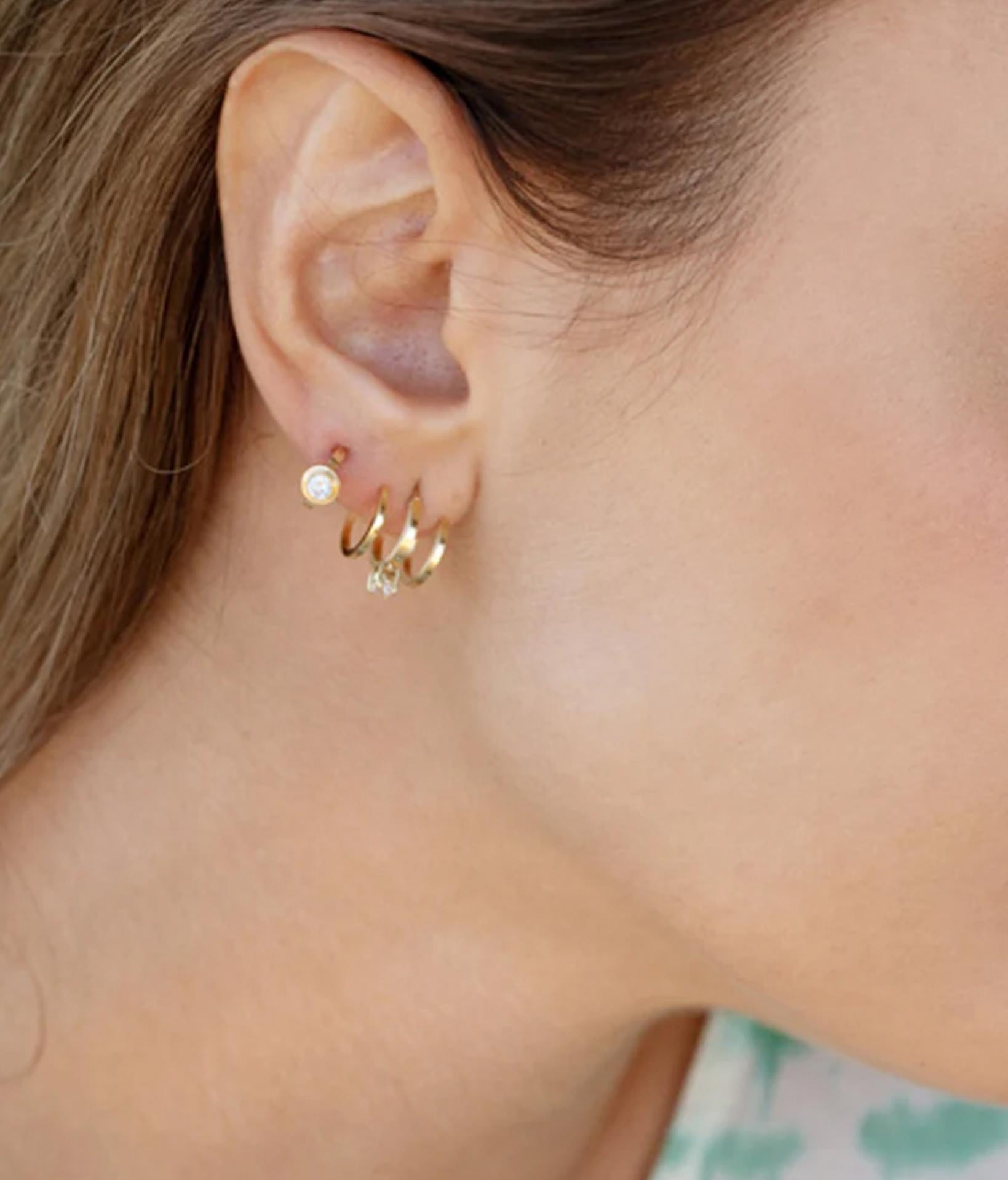 Frau mit seitlicher Sicht vom Kopf trägt zierliche dreireihige Ohrringe aus vergoldeten Edelstahl