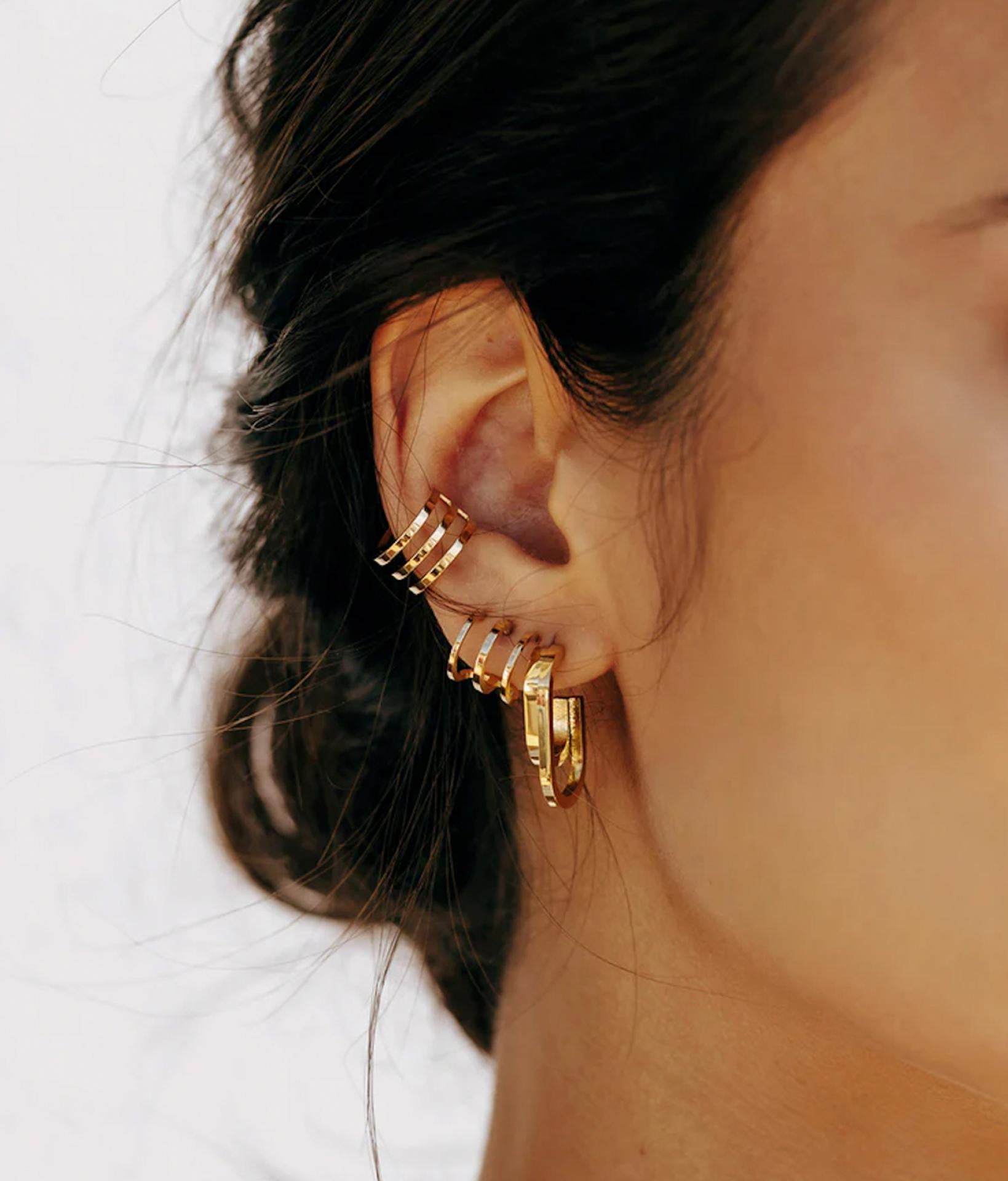 braunhaariges model am rechten ohr mit Zag Bijoux Ohrringe aus goldenen halbringen
